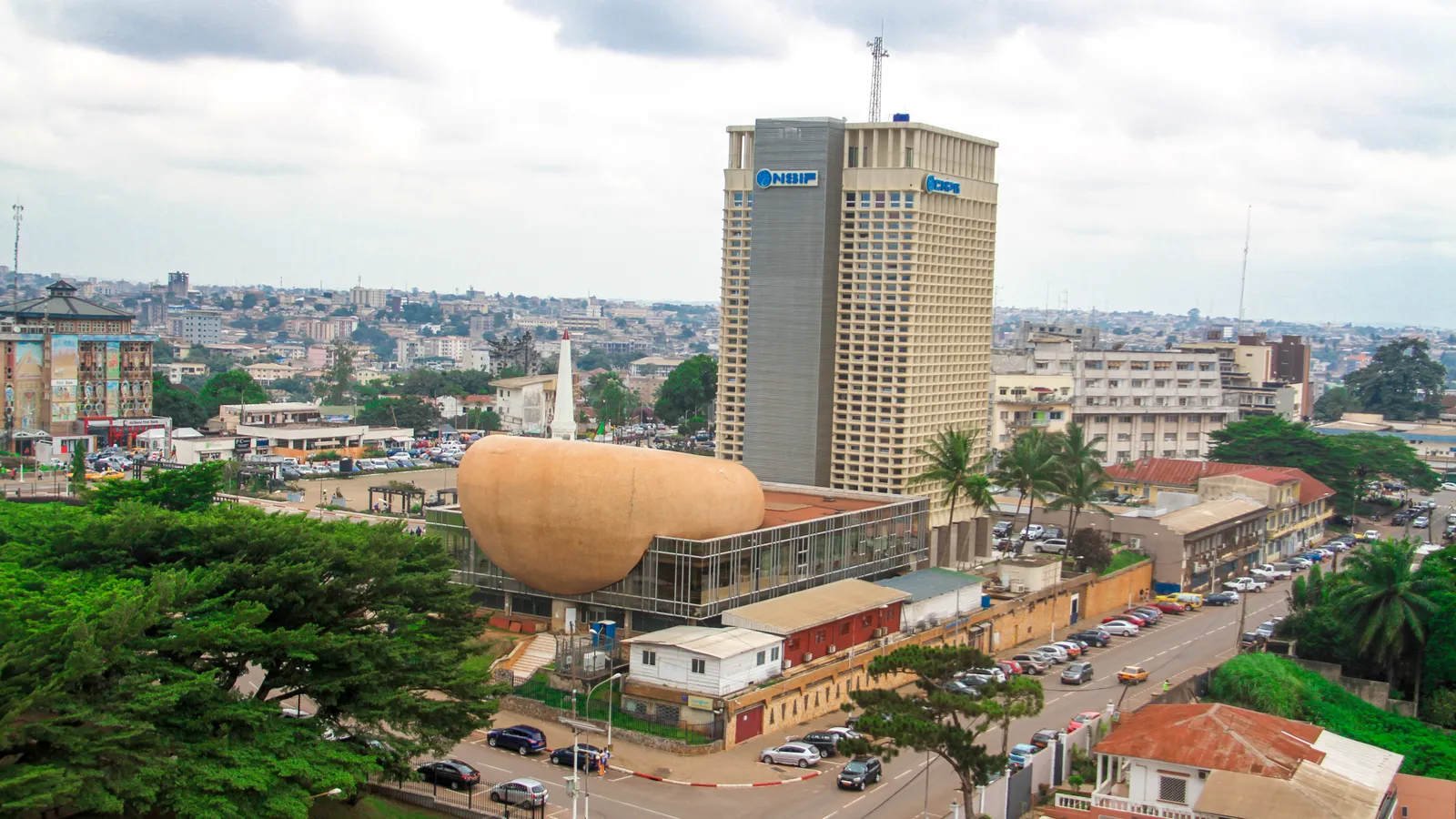 Central Yaoundé, Cameroon, with a high-rise office tower and the city spreading over hills behind