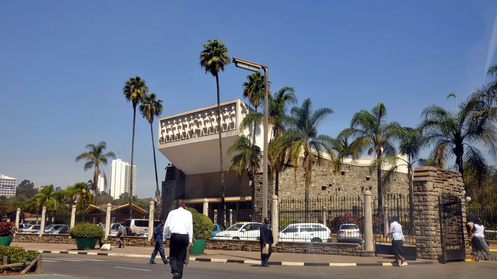 Kenya’s Parliament Buildings in Nairobi, framed by palm trees under a blue sky
